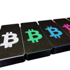 Nahaufnahme einer Reihe von BitBox02 Covern mit Bitcoin-Zeichen in Weiß, Grün, Blau und Pink